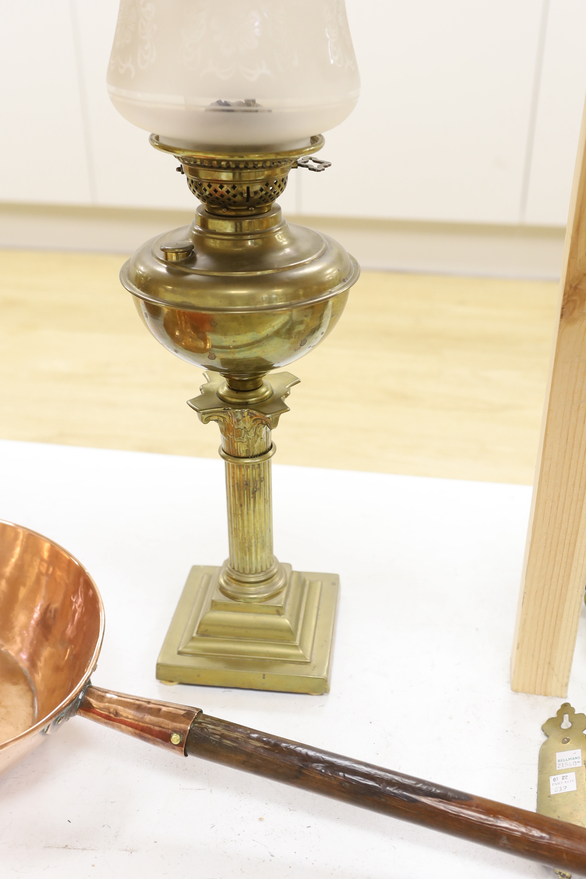 A brass Corinthian column oil lamp, two brass wall sconces and an 1823 copper saucepan